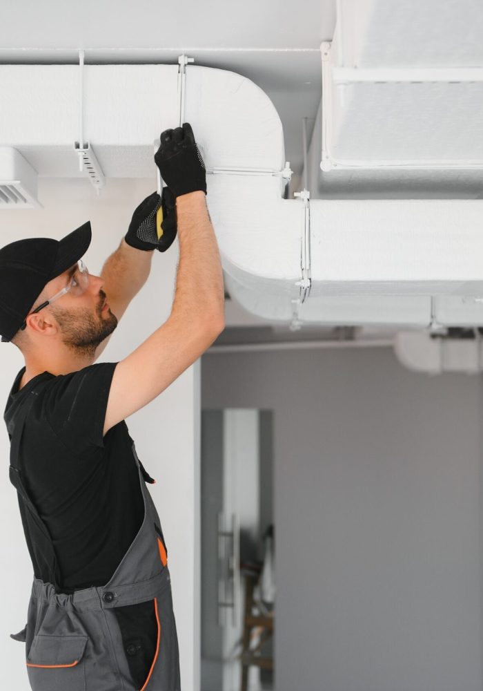 hvac services, worker install ducted pipe system for ventilation and air conditioning in house.